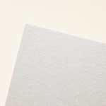 Primer plano de una esquina de papel para acuarela blanquecino, con fina textura superficial irregular