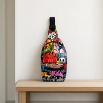 Bolsa estampada colorida para peito em pé sobre um banco de madeira diante de uma parede clara
