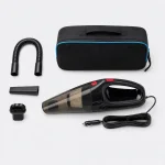 Aspiradora para coche junto a una bolsa negra, manguera flexible, cepillo, boquilla estrecha y cable de alimentación.