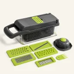 Closed black vegetable chopper beside green slicing inserts and a hand guard