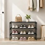 Black shoe rack with shoes near a doorway, topped with a handbag and potted plant