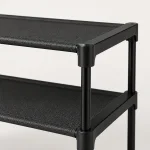 Close-up of a black shoe rack corner showing shelf edges and upright supports