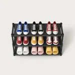 Black three-tier shoe rack holding colorful sneakers and slippers