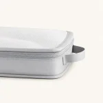 Dettaglio di un cubo grigio con parte superiore in rete, cerniera e maniglia laterale