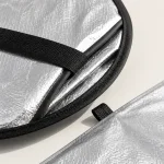 Close-up of the sunshade's silver surface, black edge binding and retaining strap.