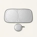 Top view of the opened silver windshield sunshade and round pouch.