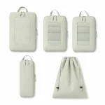 Overhead layout of pale green packing cubes, two mesh windows, a slim pouch and drawstring bag