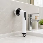 Brosse de nettoyage électrique présentée avec sa tête ronde contre un mur carrelé près d'un évier