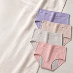 Four briefs in purple, beige, light gray and dusty pink arranged diagonally on linen