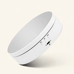 White display turntable photographed at an oblique angle with its reflective top and front controls visible