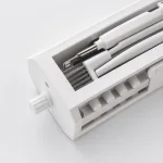 Close-up of brushes and slim angled tips stored inside a white rectangular holder