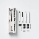 White cleaning tool holder laid beside separate brushes, fine tips and small attachments