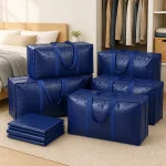 Marineblaue Umzugstaschen neben Bett und Kleiderschrank, gefaltete Taschen im Vordergrund