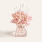 Schrägansicht eines blumigen Diffusers mit rosa Blüten und geriffelter transparenter Flasche