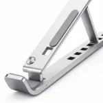 Primo piano di un supporto per laptop argentato con imbottitura grigia, cerniera, fori di regolazione e fermo anteriore