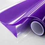 Close view of purple gloss film lifting away from a clear backing layer