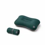 Green travel pillow shown inflated beside a rolled version with a strap and visible valve