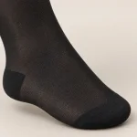 Close-up of a black sock showing fine mesh texture and darker heel and toe sections