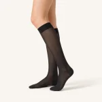Side view of black knee-high socks worn on the legs, showing the cuffs and heels