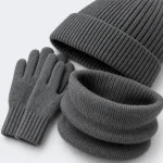 Nahaufnahme des grauen Stricksets mit umgeschlagenem Mützenrand, Handschuhbündchen und gerolltem Schlauchschal