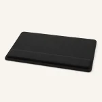 Black rectangular desk pad with rounded corners and a raised wrist cushion along one edge