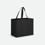 Sac cabas noir rectangulaire à ouverture supérieure et longues anses, posé sur une surface claire