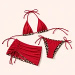 Bikini rosso e gonnellina corta disposti di sbieco, con lato arricciato e lacci