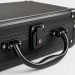 Close-up of the black document case showing the keyed latch, handle mounts and textured edge