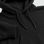 Primer plano de la sudadera negra con cordones de capucha, puño de canalé y costuras del bolsillo