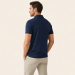 Rückansicht eines Mannes mit dunkelblauem Kurzarm-Poloshirt und heller Hose