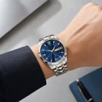 Blue-dial wristwatch worn on a wrist with a dark shirt cuff.