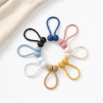 Looped curtain tiebacks arranged in black, blue, pink, cream, yellow, tan, white and light blue