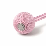 Close-up of a pink cord-wrapped tieback end showing a round metal insert and braided cord