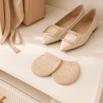 Protège-pieds beiges à pois blancs en forme de fleurs, à côté de ballerines beiges pointues