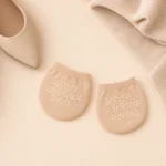 Protège-pieds beiges posés à plat à côté de vêtements en maille claire et d'une chaussure pointue