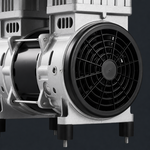 Black fan guard beside the silver housing of the compressor pump motor