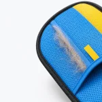 Close-up de pelos soltos no lado azul de rede da luva, com rebordo amarelo e acabamento preto