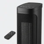 Close-up of a black tower heater showing the top control symbols, front grille and remote