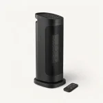 Angled side view of the black tower heater and its base, with a remote alongside