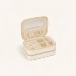 Open cream jewelry case with a mirror, gathered lid pocket, ring rolls and divided compartments