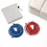 Coiled blue and red clip clotheslines beside a gray drawstring pouch and folded towels
