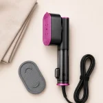 Vaporizzatore per abiti disteso accanto a un accessorio ovale, un cavo di alimentazione e tessuto piegato.