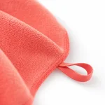 Primer plano de una toalla coral que muestra la superficie texturizada, el borde cosido y el asa de colgar
