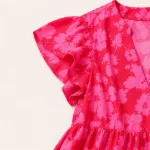 Close-up of the floral print, ruffled sleeve and waist seam on a pink dress