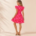 Rear view of a pink floral mini dress showing ruffled shoulders and a flared hem