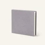 Closed gray photo album standing upright with a textured cover and white page edges