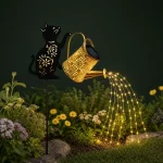 Katzenförmiger Gartenstecker mit leuchtender Gießkanne und Lichtsträngen über einem Blumenbeet bei Nacht