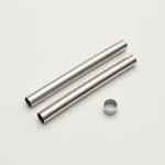 Due tubi color argento per aspirapolvere disposti diagonalmente accanto a un piccolo anello metallico.
