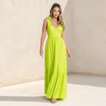 Vestido amarillo verdoso al caminar por un patio neutro
