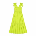 Un vestido amarillo verdoso extendido con sus lazos en los hombros